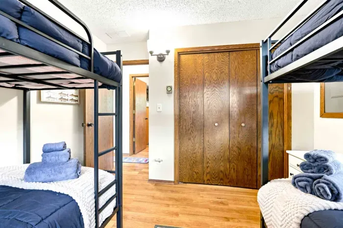 Designed with group stays in mind, this restful sleeping space offers two sets of bunk beds framed by cheerful cabin decor and peaceful woodland views. Enjoy a gentle breeze throughout the space provided by the ceiling fan.