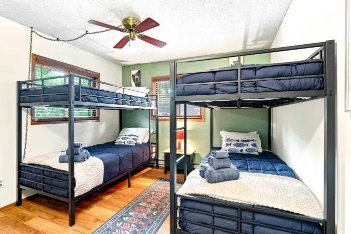 Perfect for kids or groups, this cozy bunk room features two sets of metal bunk beds with comfortable bedding and fresh towels. Stay cool and comfortable under the ceiling fan after a long day of outdoor fun.