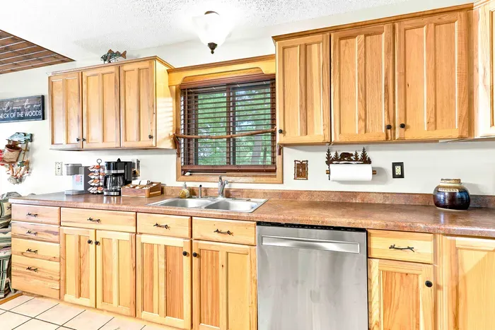 Brew your morning coffee using the drip coffee maker and take in the natural views framing the kitchen window. Packed with conveniences like a dishwasher and stainless steel refrigerator, this kitchen blends rustic charm with modern comfort.
