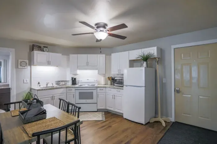 A modern kitchen equipped with high-end appliances and ample lighting. It has a coffee maker, oven, stove top, utensils, and all it takes to fix a delicious meal.