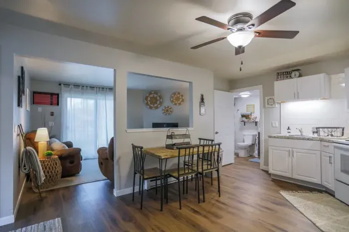 A modern kitchen equipped with high-end appliances and ample lighting. The living room view to the right.