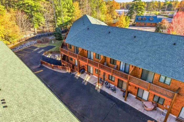 Nestled against a backdrop of vibrant autumn trees, this charming lodge-style building features private outdoor balconies and patio seating for every unit. With convenient paved parking right outside your door, your mountain getaway starts the moment.