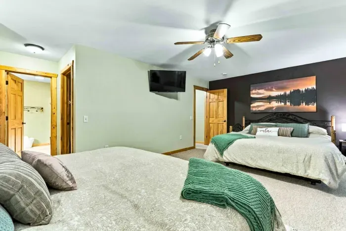 Settle into a tranquil retreat featuring two comfortable beds, bedside lighting, and a ceiling fan for climate control. Sliding doors lead right out to the deck, allowing fresh breeze and views right from your room.