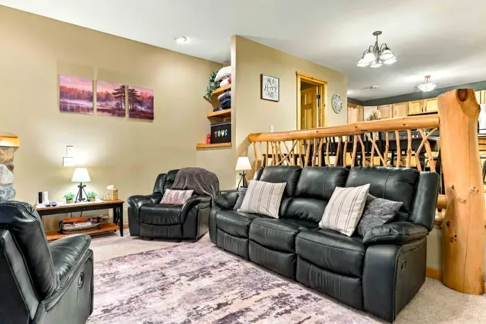Settle in for movie nights or quiet conversations in this comfortable living space. Generous leather seating, ambient table lamps, and a stone hearth create an inviting retreat for family and friends