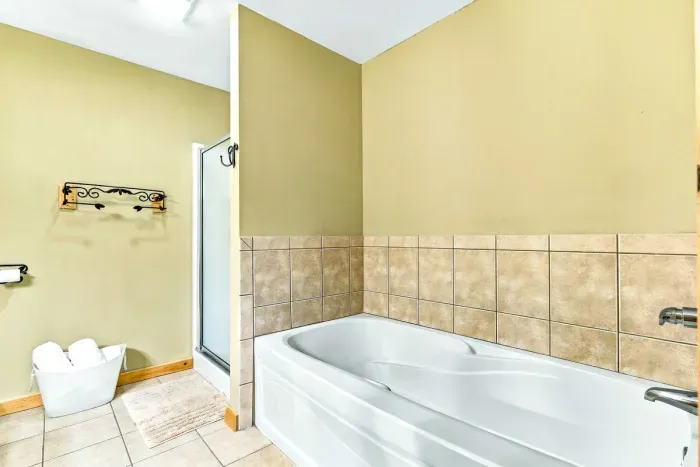 Designed with convenience and luxury in mind, this full bathroom provides dual options for your routine. Enjoy a soothing soak in the corner bath or utilize the separate step-in glass shower.