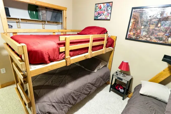 Perfect for group stays! Enjoy comfortable sleeping arrangements with two wooden bunk bed sets and an overhead ceiling fan.