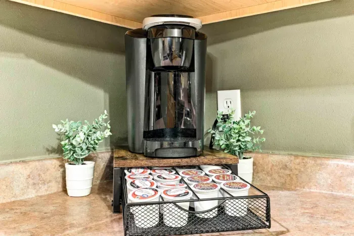 Enjoy your morning brew just the way you like it! This convenient coffee nook features a single-serve coffee maker with an assortment of pods organized in a sliding storage drawer.