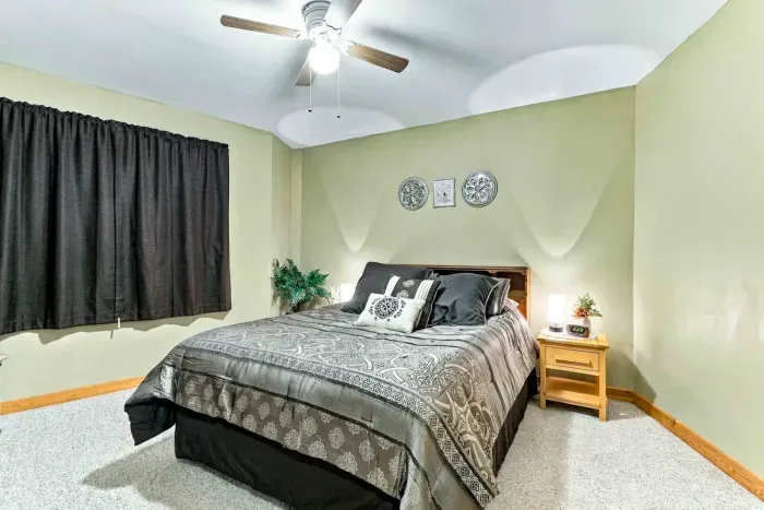 Relax and unwind in a quiet, carpeted bedroom designed for optimal comfort. Featuring dark blackout curtains for sleeping in, warm bedside lighting, and subtle wall art, it’s the perfect sanctuary after a day of lake activities.
