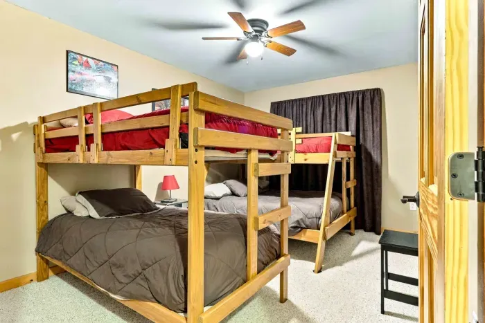 The ultimate room for kids, teens, or groups! Featuring two custom wooden bunk bed sets, soft carpeted flooring, and a ceiling fan, this comfortable bedroom maximizes sleeping space while keeping everyone cozy.