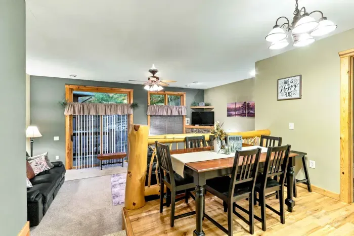 Gather for group meals at this beautiful wood dining table with seating for up to six. Overlooking the lower-level living area with rustic log railings, this open space flows seamlessly to sliding glass doors that lead out to the patio.