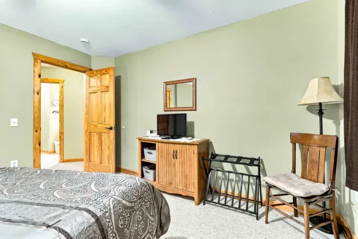 Quiet, cozy, and built for rest! Features a plush bed with damask linens, blackout curtains, and bedside lighting.