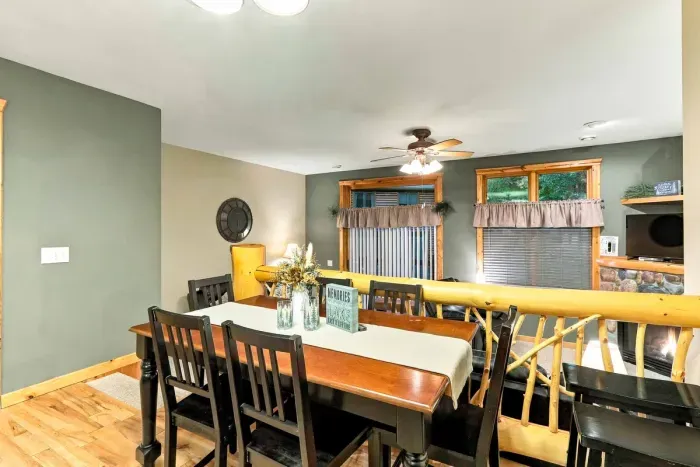 Share home-cooked dinners or game nights at a spacious wooden dining table accented by classic lighting and rustic wood details. The raised dining space looks out toward the sitting room and offers direct access to the outdoors.