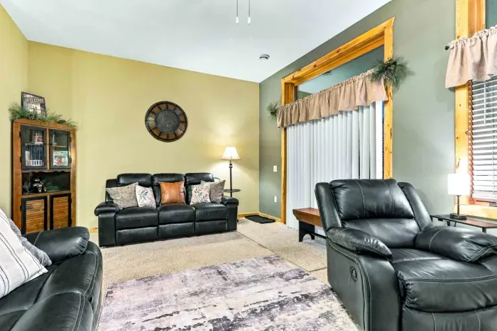 Neutral walls, warm wood-trimmed windows, and stylish accents create a welcoming atmosphere. Sink into plush leather seating with throw pillows, grab a game from the cabinet, or step outside through the sliding glass doors.