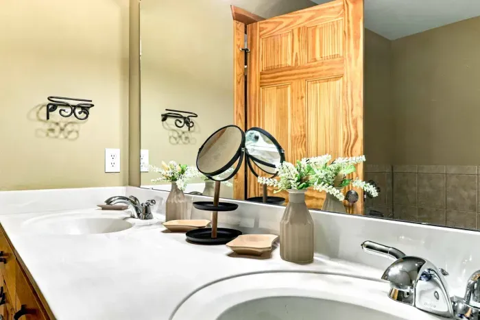 Enjoy dual sinks and generous counter space designed to easily accommodate couples or groups. Highlighted by warm wood cabinetry, elegant vanity lighting, and ample drawer space, getting ready for the day is effortless.