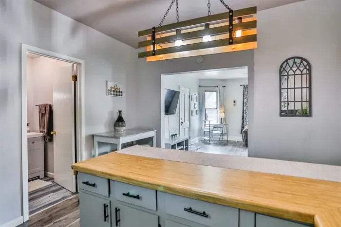 A modern kitchen equipped with high-end appliances and ample lighting. It has a coffee maker, oven, stove top, utensils, and all it takes to fix a delicious meal.