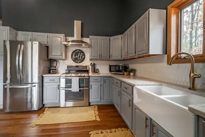 Modern and efficient—everything you need to create a delicious meal. The kitchen features a stainless steel refrigerator, stove, coffee maker, kitchenette oven, kettle, and blender