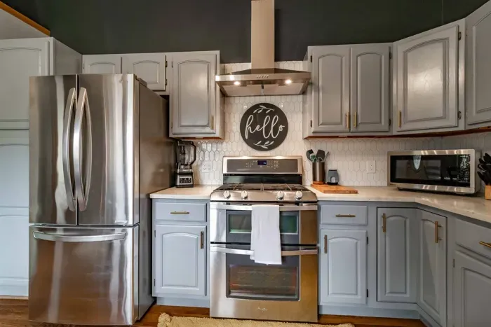 Modern and efficient—everything you need to create a delicious meal. The kitchen features a stainless steel refrigerator, stove, coffee maker, kitchenette oven, kettle, and blender