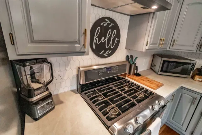 Modern and efficient—everything you need to create a delicious meal. The kitchen features a stainless steel refrigerator, stove, coffee maker, kitchenette oven, kettle, and blender
