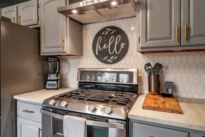 Modern and efficient—everything you need to create a delicious meal. The kitchen features a stainless steel refrigerator, stove, coffee maker, kitchenette oven, kettle, and blender