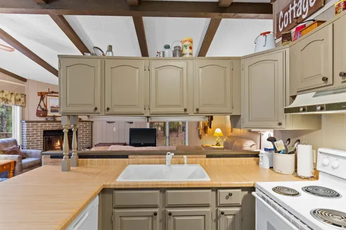 Bright and open, this kitchen features a large countertop, ample storage, and classic wooden cabinetry.