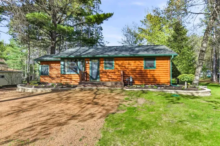 A cozy log-sided cabin tucked beneath the pines, welcoming you into a relaxed retreat.