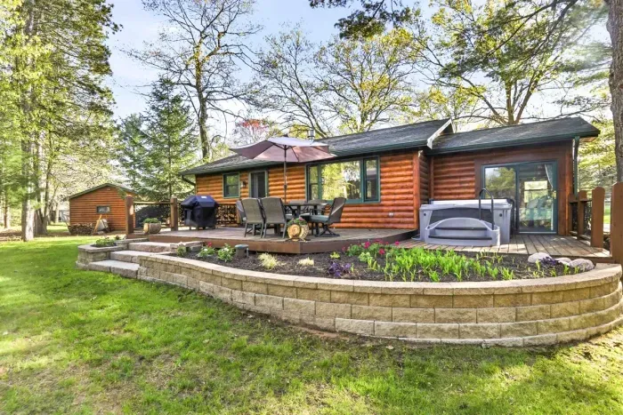 Relax outdoors in a peaceful wooded setting with a spacious deck, hot tub, dining area, and grill—perfect for slow mornings, evening soaks, and gathering under the trees.