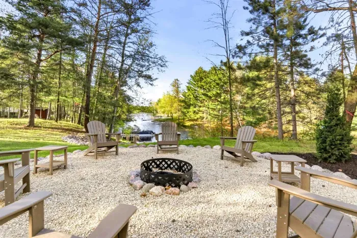 Gather around the firepit, sink into Adirondack chairs, and take in peaceful water views framed by towering trees. This inviting outdoor retreat is made for slow mornings, sunset conversations, and effortless Up North relaxation.