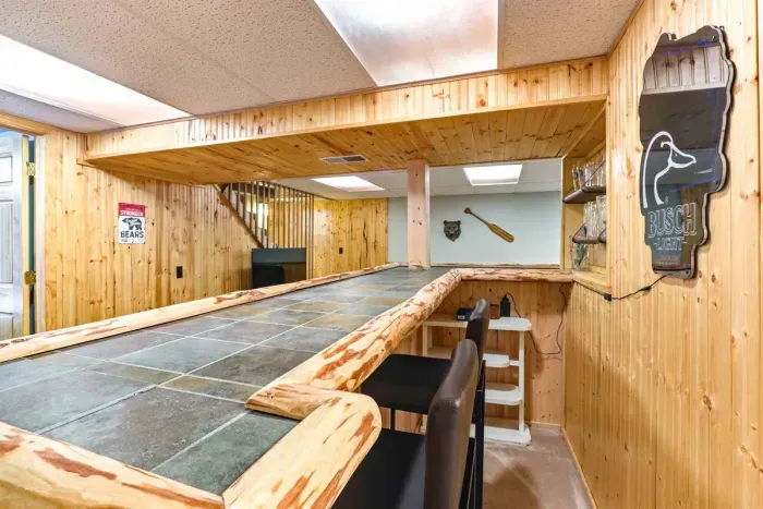 Stylish lower-level living space with wood-accent bar and seating.