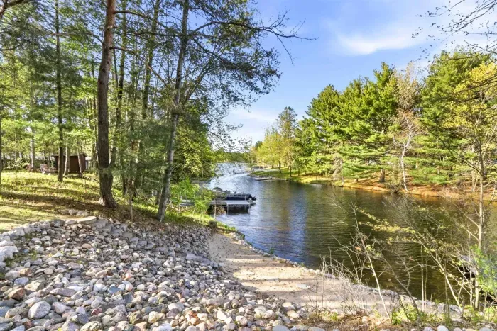 A quiet shoreline path leads to calm water, private dock access, and the easy rhythm of lake-country days.