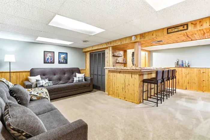Rustic basement lounge with cozy seating and private bar area.
