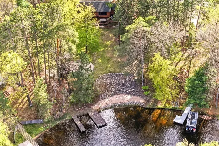 Enjoy a true lakeside escape with a private dock, sandy shoreline, and a cozy cabin tucked into the trees.