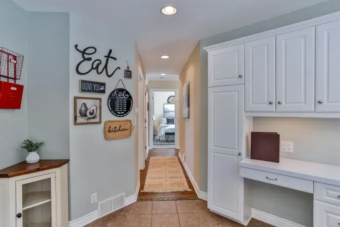 A contemporary kitchen with crisp white cabinets, offering plenty of storage and counter space for meal prep, dining, or casual gatherings.
