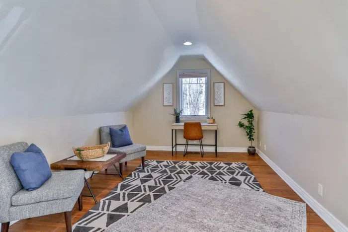 This upper-level lounge features a work desk and two plush chairs, combining comfort and functionality for productive work or leisurely downtime.