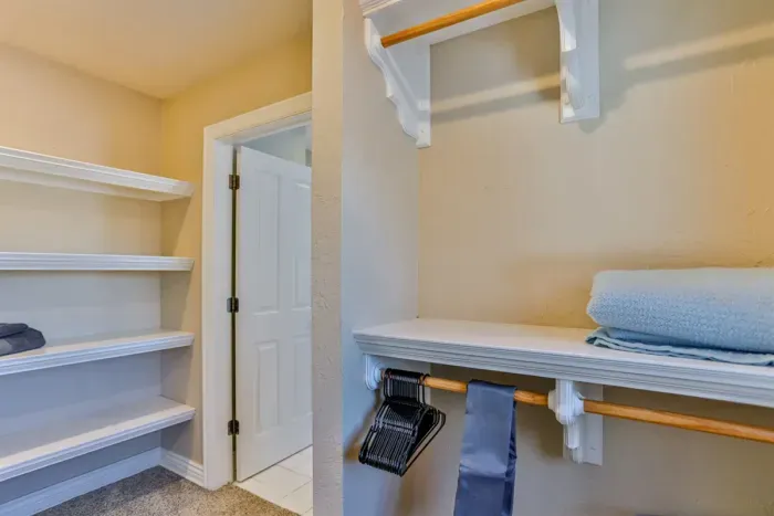 The bedroom features an open clothes rack, offering a modern, minimalist storage solution.