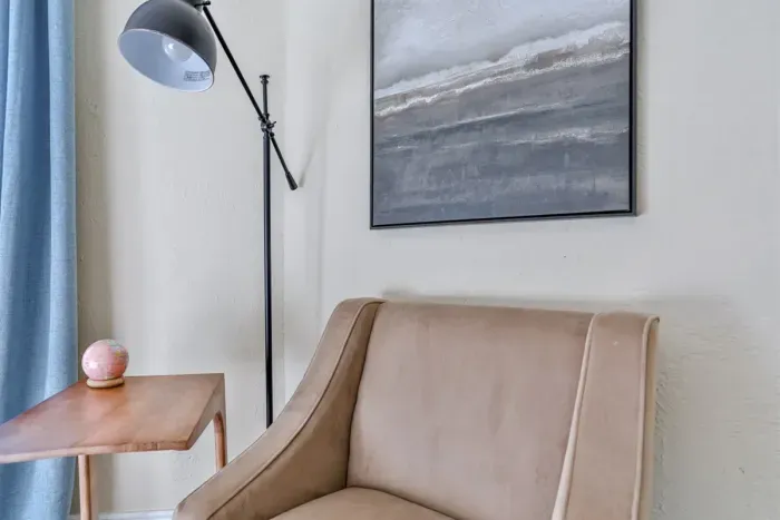 In addition to the bed, the bedroom features a comfortable couch and side table, creating a welcoming and versatile space.