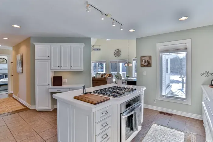 The kitchen features sleek white cabinetry, creating a clean, bright, and airy atmosphere. Fully equipped with modern appliances and ample storage, it’s perfect for cooking and entertaining.