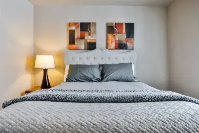 Thoughtfully styled bedroom with a plush bed, neutral palette, and warm lighting for a relaxing night’s sleep.
