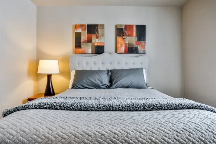 Thoughtfully styled bedroom with a plush bed, neutral palette, and warm lighting for a relaxing night’s sleep.