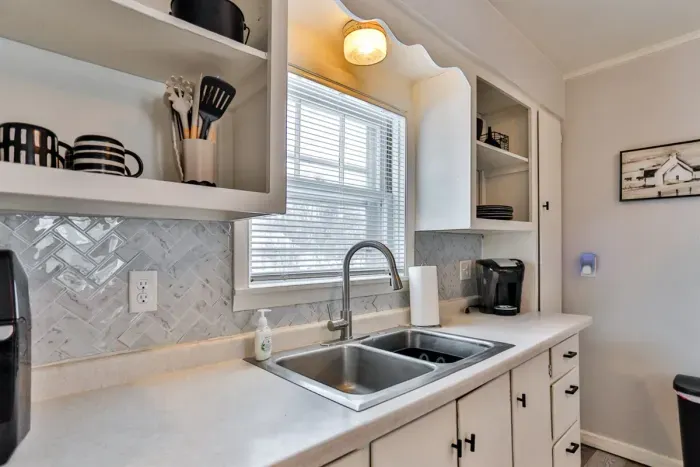 Kitchen workspace with double sink, open shelves, and plenty of natural light.
