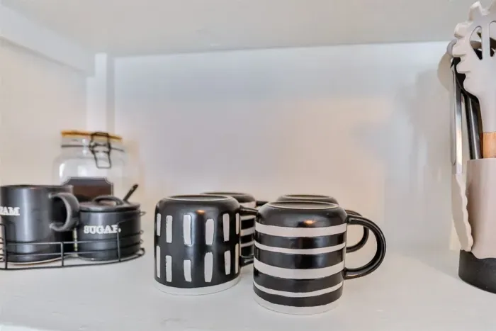 Coffee station essentials with mugs and kitchen accessories.
