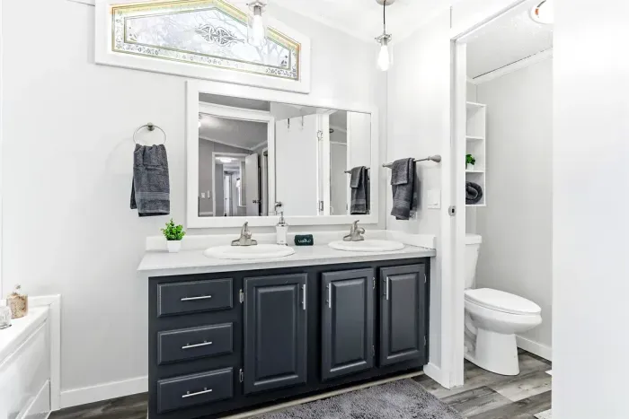 Modern bathroom with double vanity and abundant natural light.