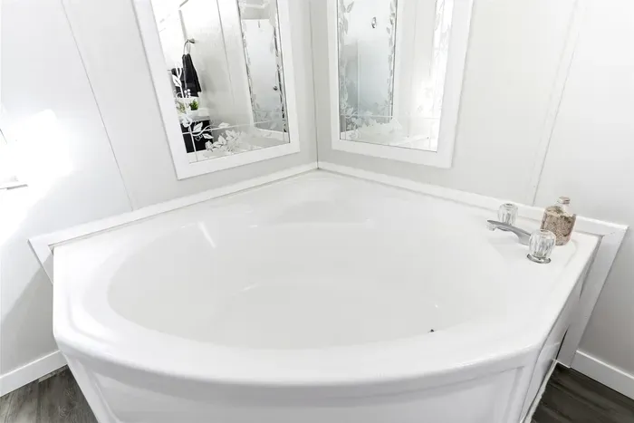 Bright bathroom with double vanity and relaxing tub."