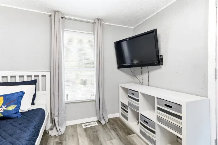 Relaxing bedroom with TV, and storage drawers.
