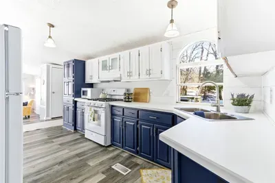 Contemporary kitchen with blue lower cabinets and white upper cabinets, combining functionality and style.