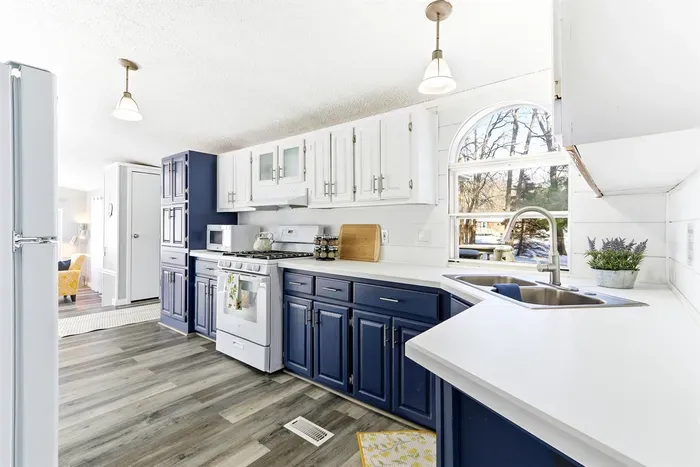 Contemporary kitchen with blue lower cabinets and white upper cabinets, combining functionality and style.