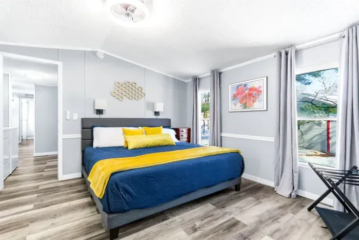 Modern bedroom with mirror, light, and comfort.