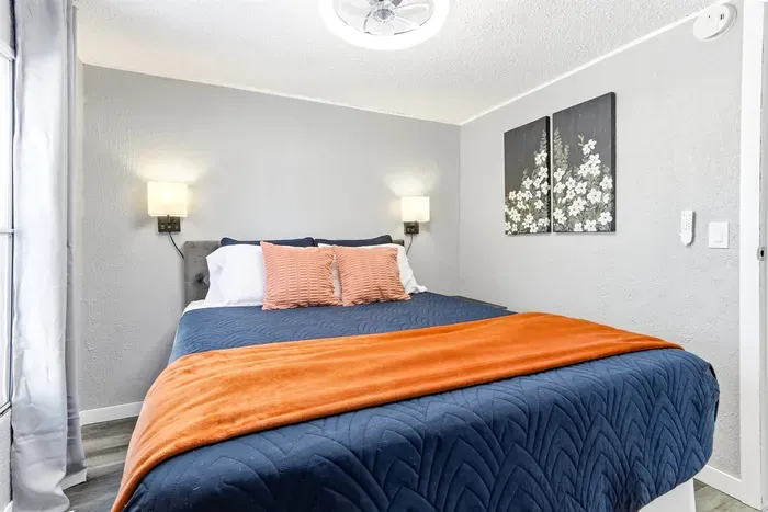 Cozy queen bedroom with soft linens and natural light.