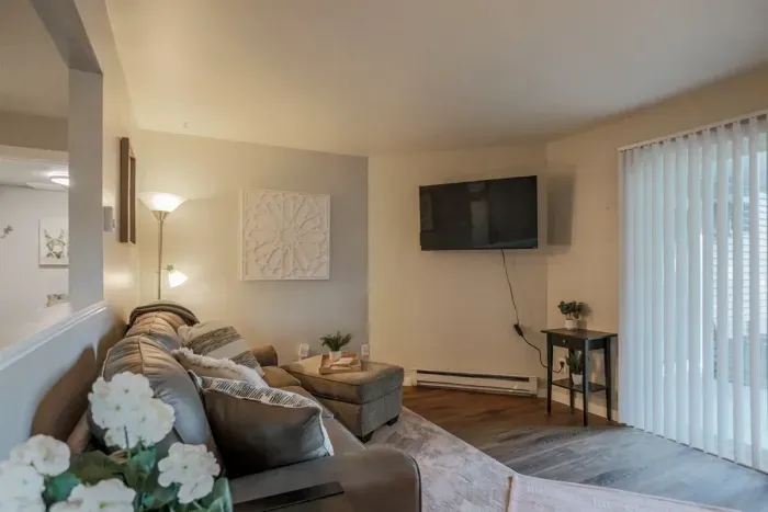 Cozy and inviting living room with comfortable seating and a modern design, perfect for relaxing after a day exploring Schofield. Enjoy high-speed Wi-Fi and streaming services on the large flat-screen TV.
