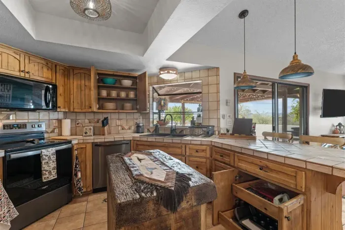 Modern and efficient—everything you need to create a delicious meal. The kitchen features a stainless steel refrigerator, stove, coffee maker, kitchenette oven, kettle, and blender.