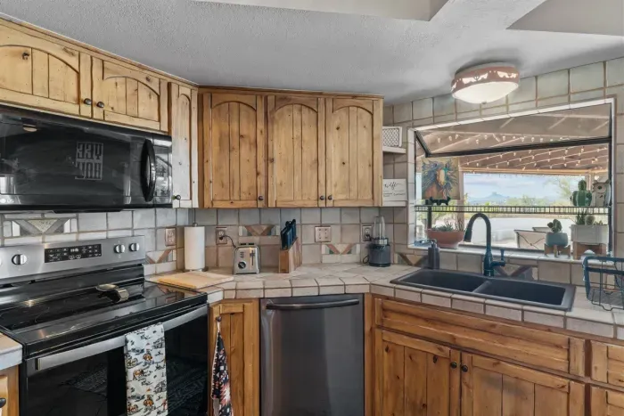 Modern and efficient—everything you need to create a delicious meal. The kitchen features a stainless steel refrigerator, stove, coffee maker, kitchenette oven, kettle, and blender.